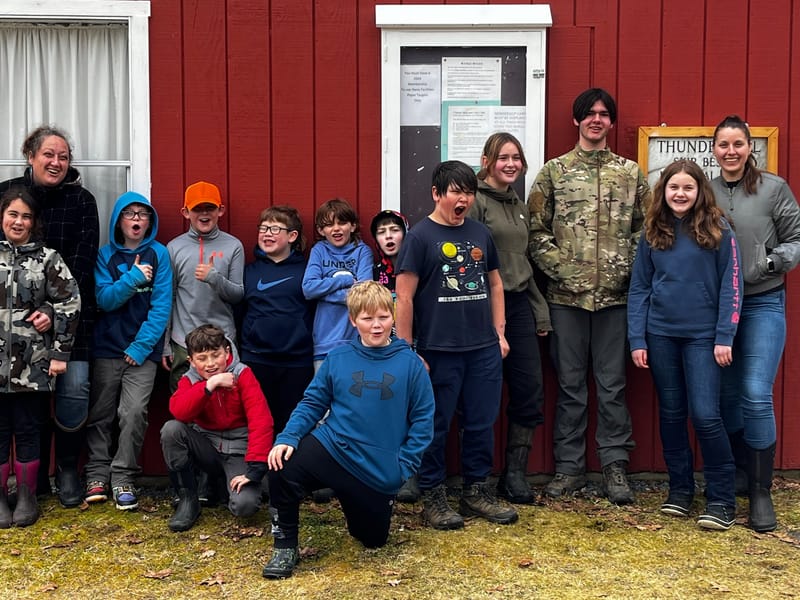 Hunter safety course participants gathered outside the red clubhouse