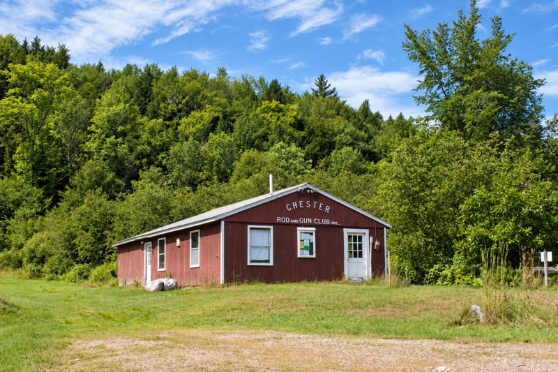 The Chester Rod and Gun Club clubhouse, with its original sign, surrounded by Vermont woods